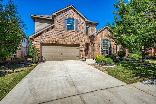 view of property featuring a front yard and a garage