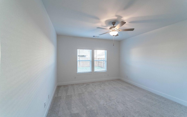 empty room with ceiling fan and light carpet