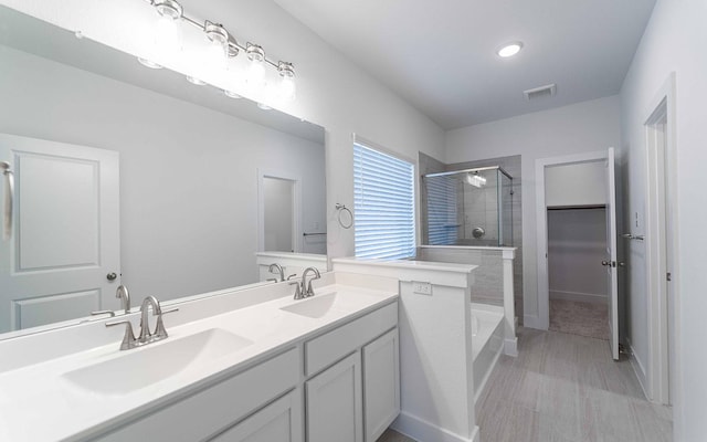 bathroom with vanity and independent shower and bath