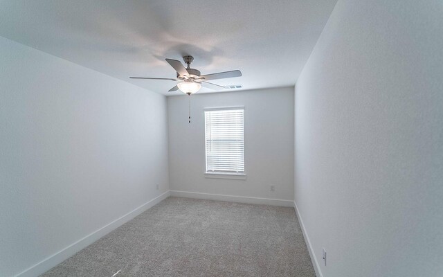 spare room featuring ceiling fan and carpet floors