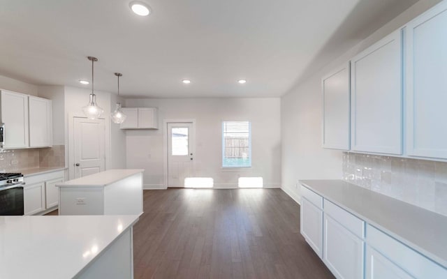 kitchen with decorative backsplash, a center island, white cabinetry, and dark wood-type flooring