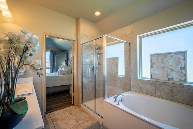 bathroom featuring separate shower and tub, vaulted ceiling, and tile patterned floors