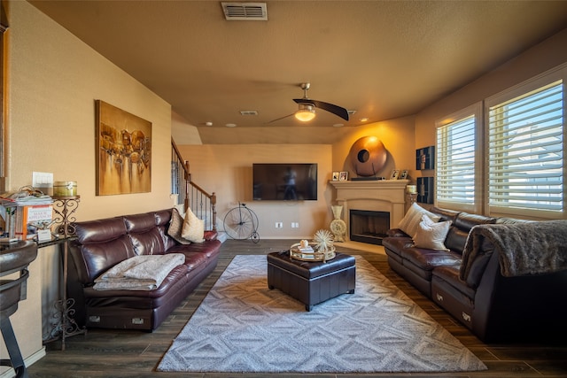 living room featuring ceiling fan and dark hardwood / wood-style flooring