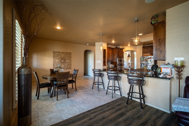 kitchen featuring pendant lighting, a breakfast bar area, light hardwood / wood-style floors, and kitchen peninsula