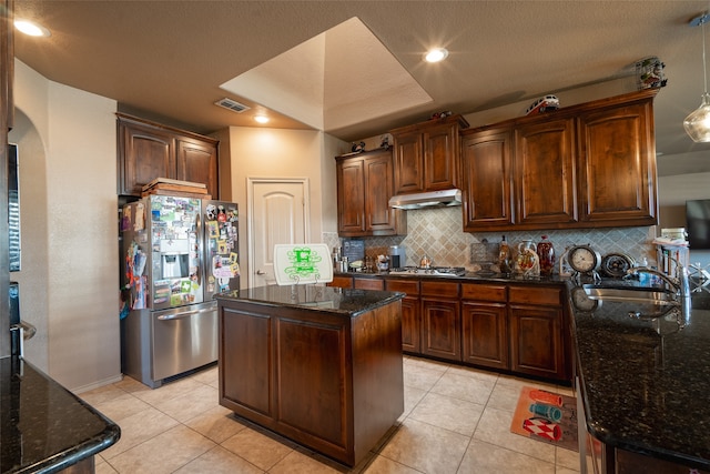 kitchen featuring light tile patterned floors, tasteful backsplash, a kitchen island, stainless steel appliances, and dark stone countertops