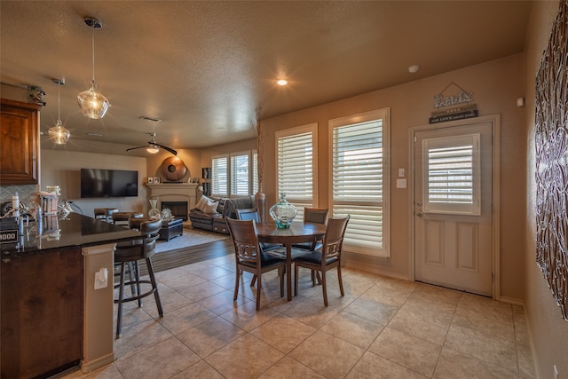 tiled dining room featuring ceiling fan and a textured ceiling