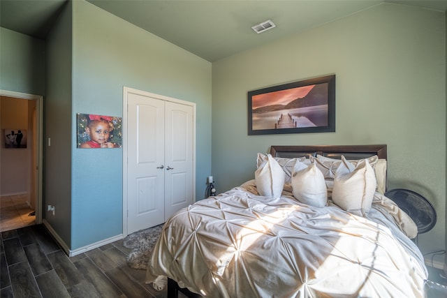 bedroom with dark hardwood / wood-style flooring and a closet