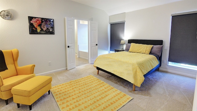 bedroom featuring light carpet and ensuite bath