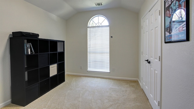 interior space with vaulted ceiling and light carpet