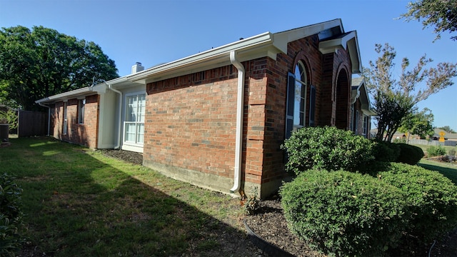 view of side of property featuring central air condition unit and a yard