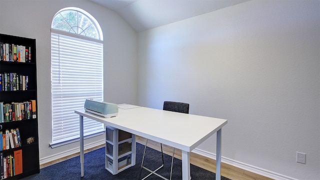 home office featuring vaulted ceiling and dark hardwood / wood-style flooring