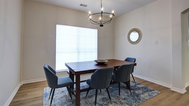 dining space featuring light hardwood / wood-style flooring and a notable chandelier