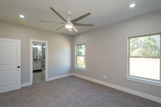 empty room with ceiling fan, carpet floors, and a wealth of natural light