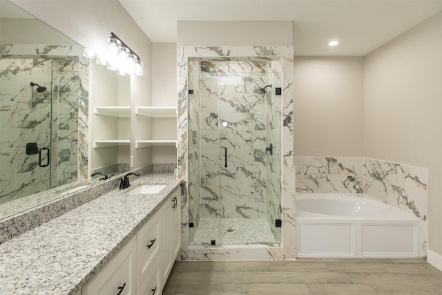 bathroom with hardwood / wood-style floors, vanity, and separate shower and tub