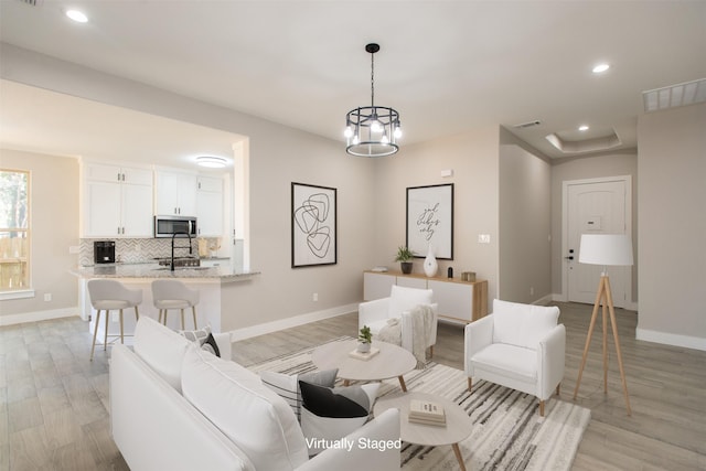 living room featuring a notable chandelier and light hardwood / wood-style floors