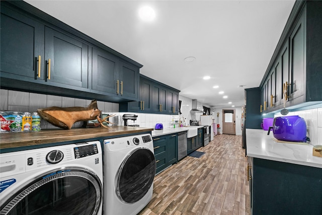 washroom featuring washing machine and clothes dryer and light hardwood / wood-style flooring