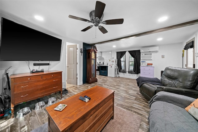 living room featuring light hardwood / wood-style flooring, an AC wall unit, and ceiling fan