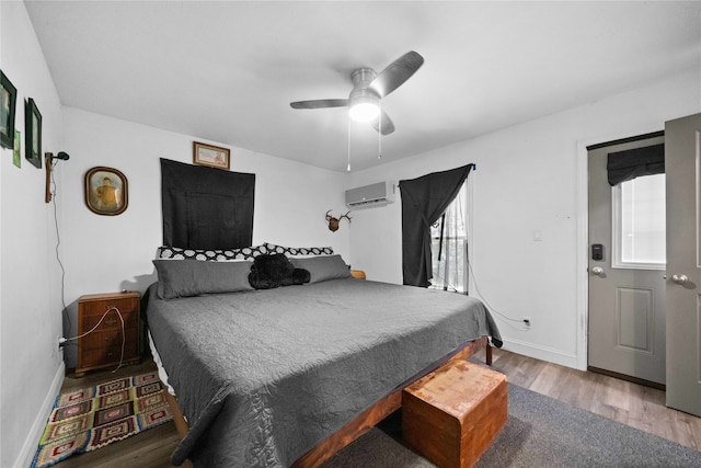 bedroom featuring ceiling fan, hardwood / wood-style flooring, and an AC wall unit