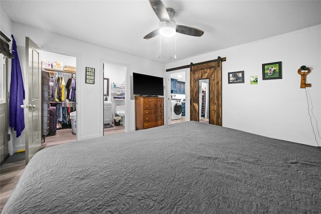 bedroom featuring ceiling fan, a closet, a spacious closet, ensuite bath, and a barn door