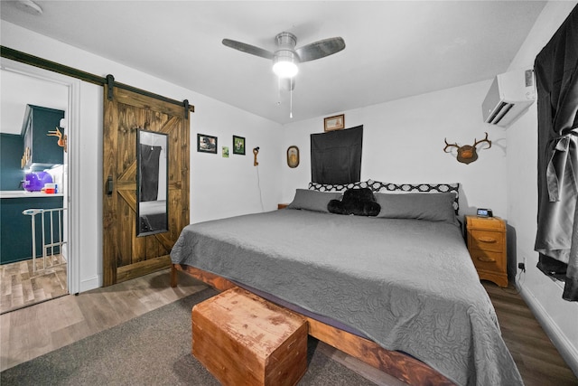 bedroom with ceiling fan, a wall mounted air conditioner, dark wood-type flooring, and a barn door