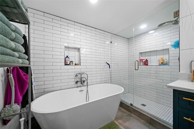 bathroom with vanity, plus walk in shower, and tile walls