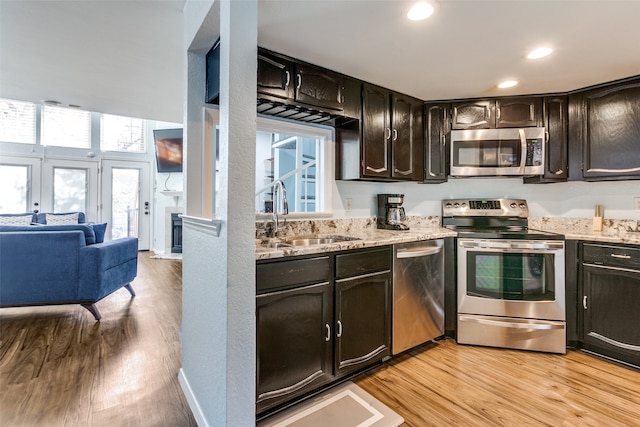 kitchen with stainless steel appliances, light hardwood / wood-style floors, a healthy amount of sunlight, and sink