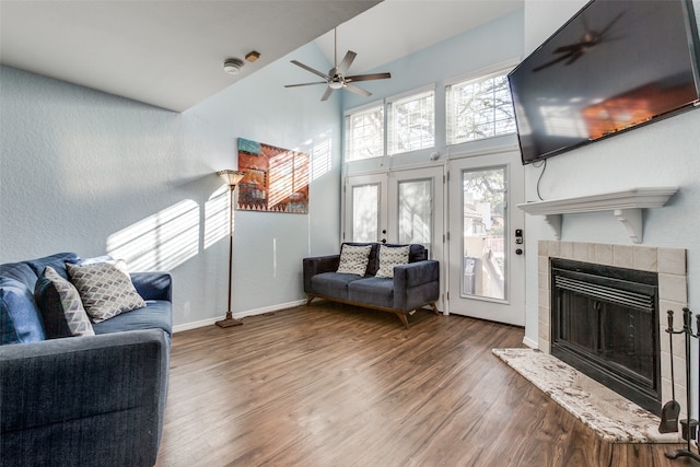 living room featuring a tile fireplace, high vaulted ceiling, ceiling fan, and hardwood / wood-style flooring