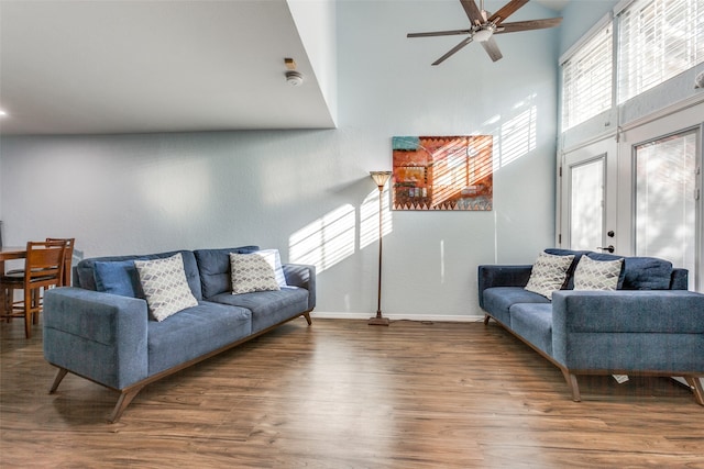 living room featuring wood-type flooring, a high ceiling, ceiling fan, and french doors