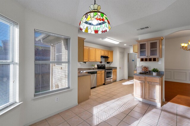 kitchen with a notable chandelier, light tile patterned floors, stainless steel appliances, and light brown cabinets