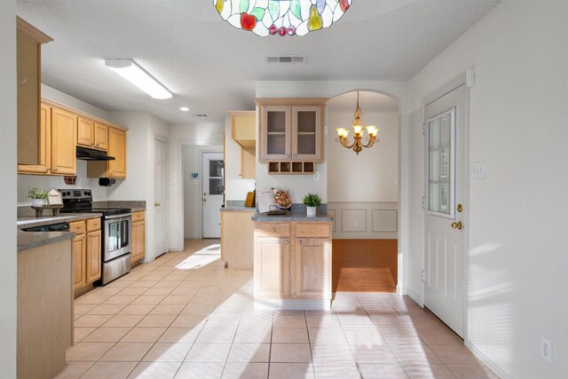 kitchen featuring pendant lighting, light brown cabinetry, sink, stainless steel appliances, and a textured ceiling