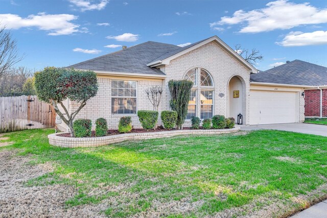 ranch-style house with a garage and a front lawn