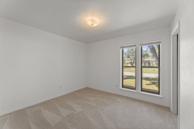 carpeted empty room featuring a textured ceiling