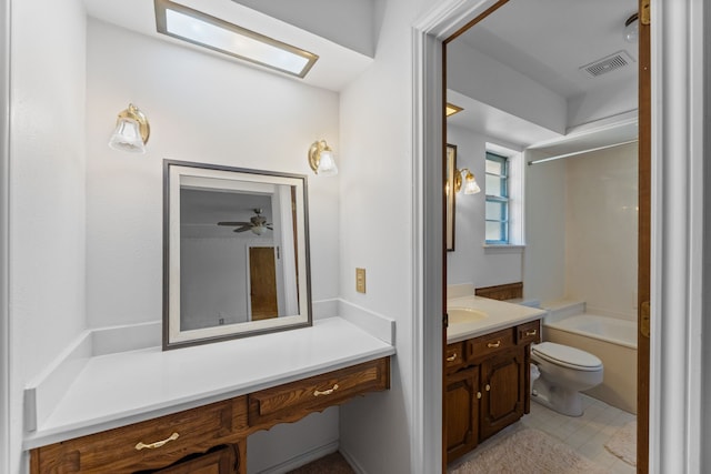 full bathroom with ceiling fan, a skylight, vanity, shower / bath combination, and toilet