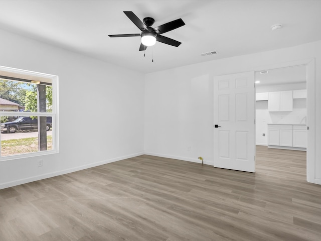 empty room with light wood-type flooring and ceiling fan