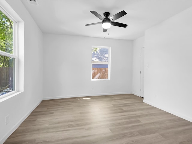 spare room with ceiling fan, light hardwood / wood-style flooring, and a wealth of natural light