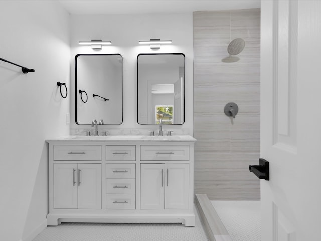 bathroom featuring a tile shower, tile patterned flooring, and vanity