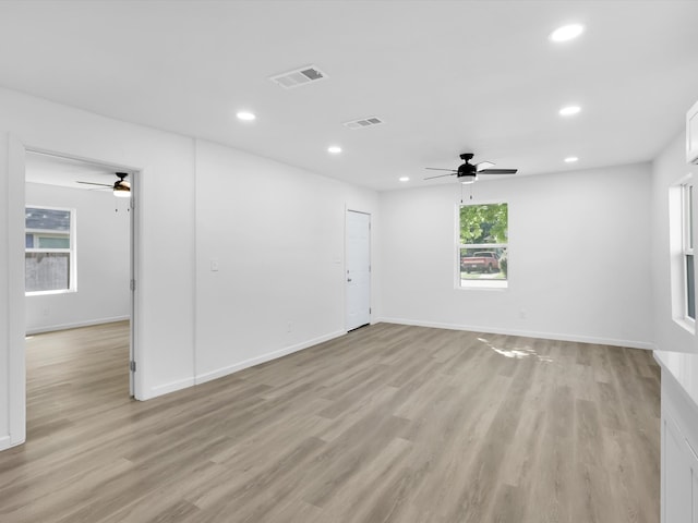 empty room featuring ceiling fan, light hardwood / wood-style floors, and a healthy amount of sunlight