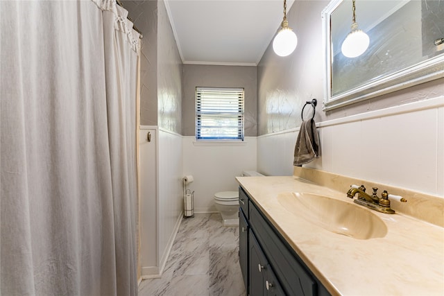 bathroom with ornamental molding, vanity, and toilet