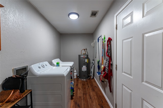 clothes washing area featuring washing machine and clothes dryer, water heater, and dark wood-type flooring