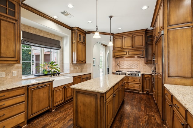 kitchen with pendant lighting, crown molding, a kitchen island, and dark hardwood / wood-style floors