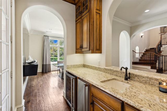 kitchen with sink, beverage cooler, dark hardwood / wood-style floors, light stone countertops, and crown molding