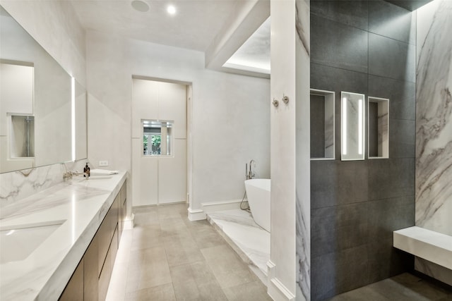 bathroom featuring tile patterned flooring, a tub, vanity, and tile walls