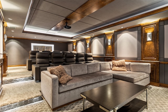 carpeted home theater room featuring crown molding and a tray ceiling