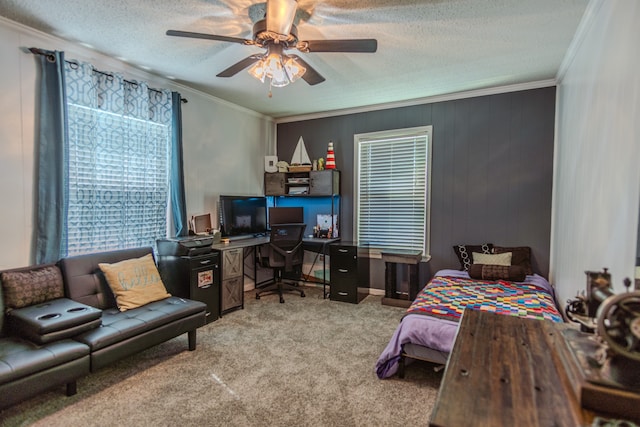 bedroom featuring a textured ceiling, ornamental molding, light carpet, and ceiling fan