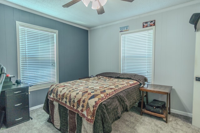 carpeted bedroom with ornamental molding, ceiling fan, multiple windows, and a textured ceiling