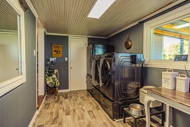 laundry room with wood walls, light hardwood / wood-style flooring, crown molding, and washer and dryer