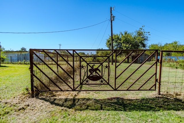 view of gate with a yard