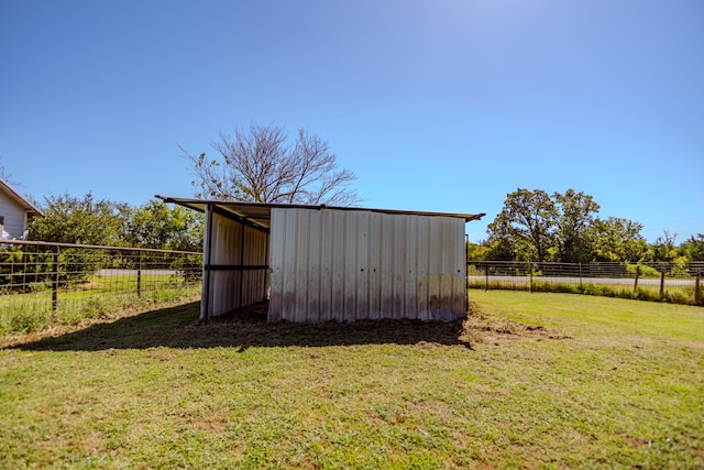 view of outbuilding with a rural view and a lawn