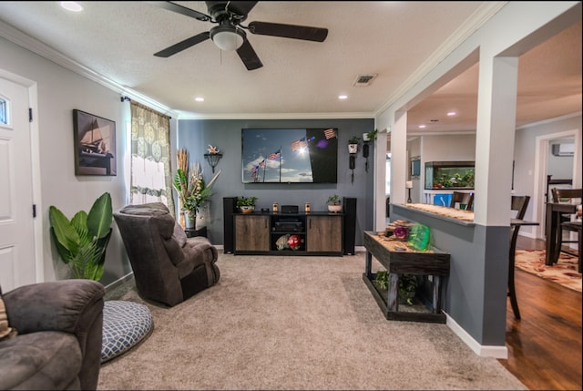 living room with ceiling fan, a textured ceiling, hardwood / wood-style floors, and crown molding