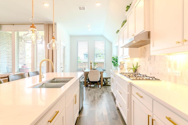 kitchen with sink, white cabinetry, pendant lighting, stainless steel appliances, and decorative backsplash